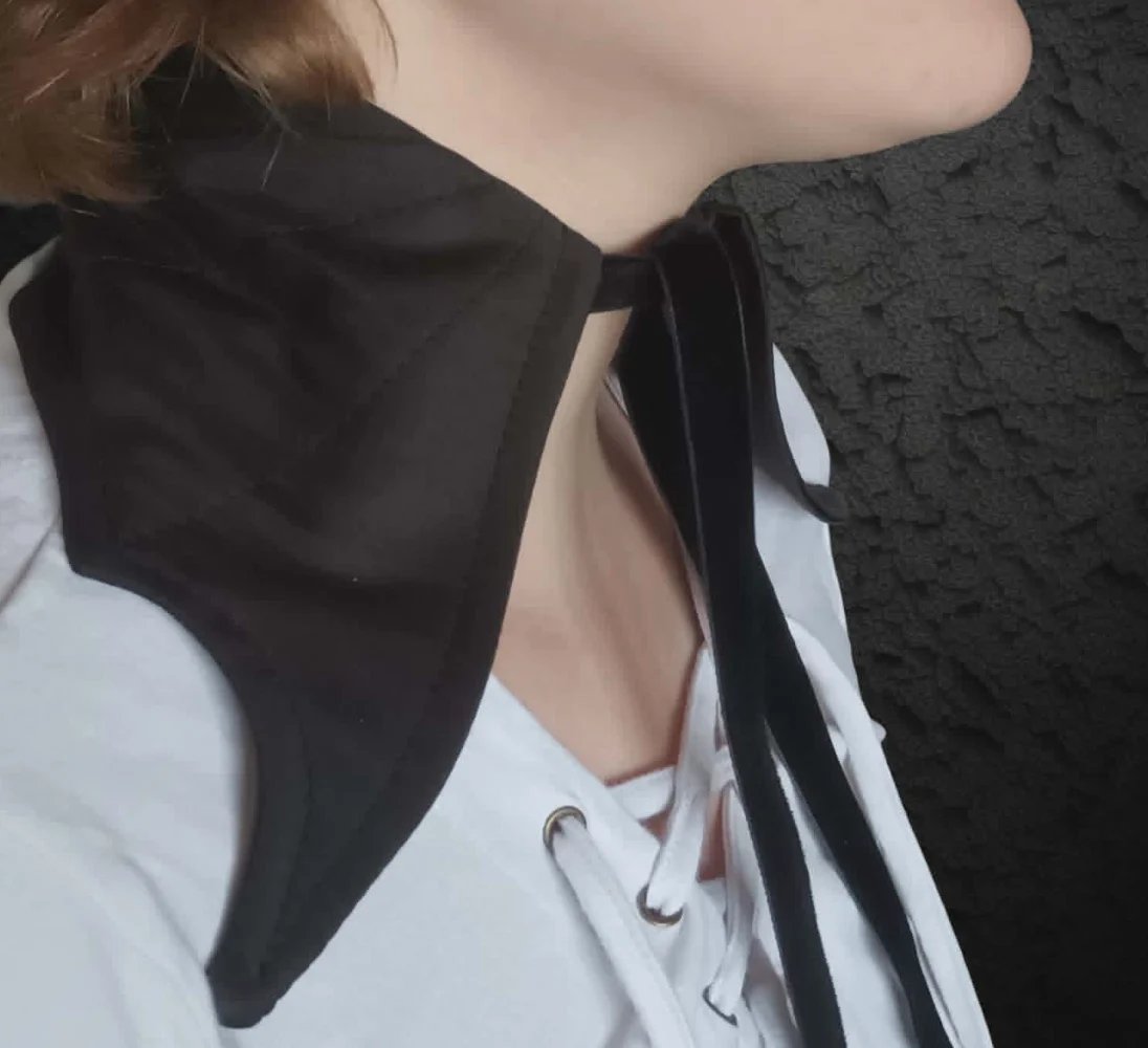 Person wearing black oversized blazer over white t-shirt and white sneakers, viewed from above at an angle