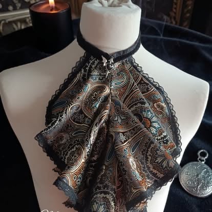Ornate black and gold embroidered shawl displayed on a white dress form with candles and decorative items in the background
