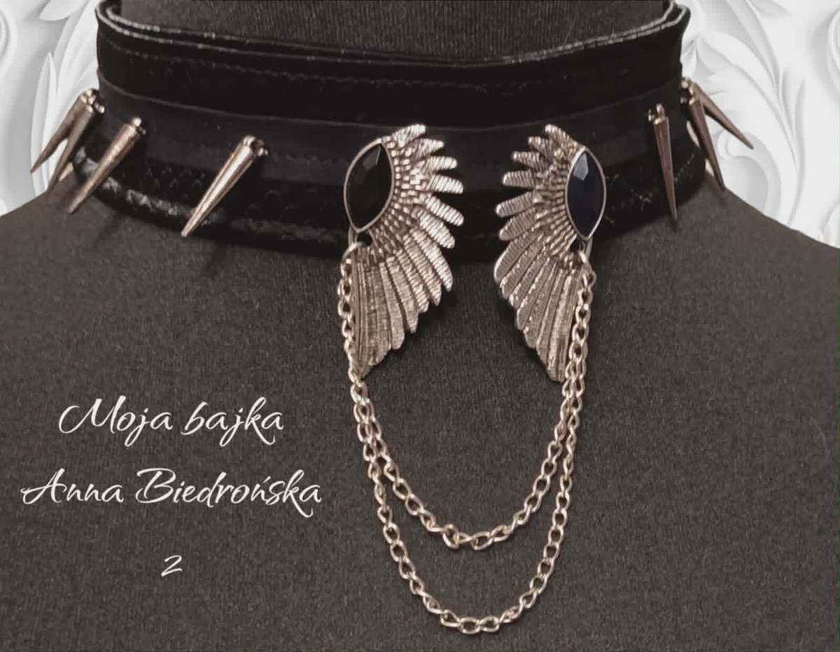 Black choker necklace with silver wing charms and chain, displayed on mannequin with text by Anna Biedrońska