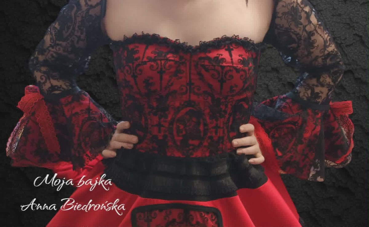 Woman wearing red and black corset dress with lace sleeves and red bows, shown from waist up against dark background