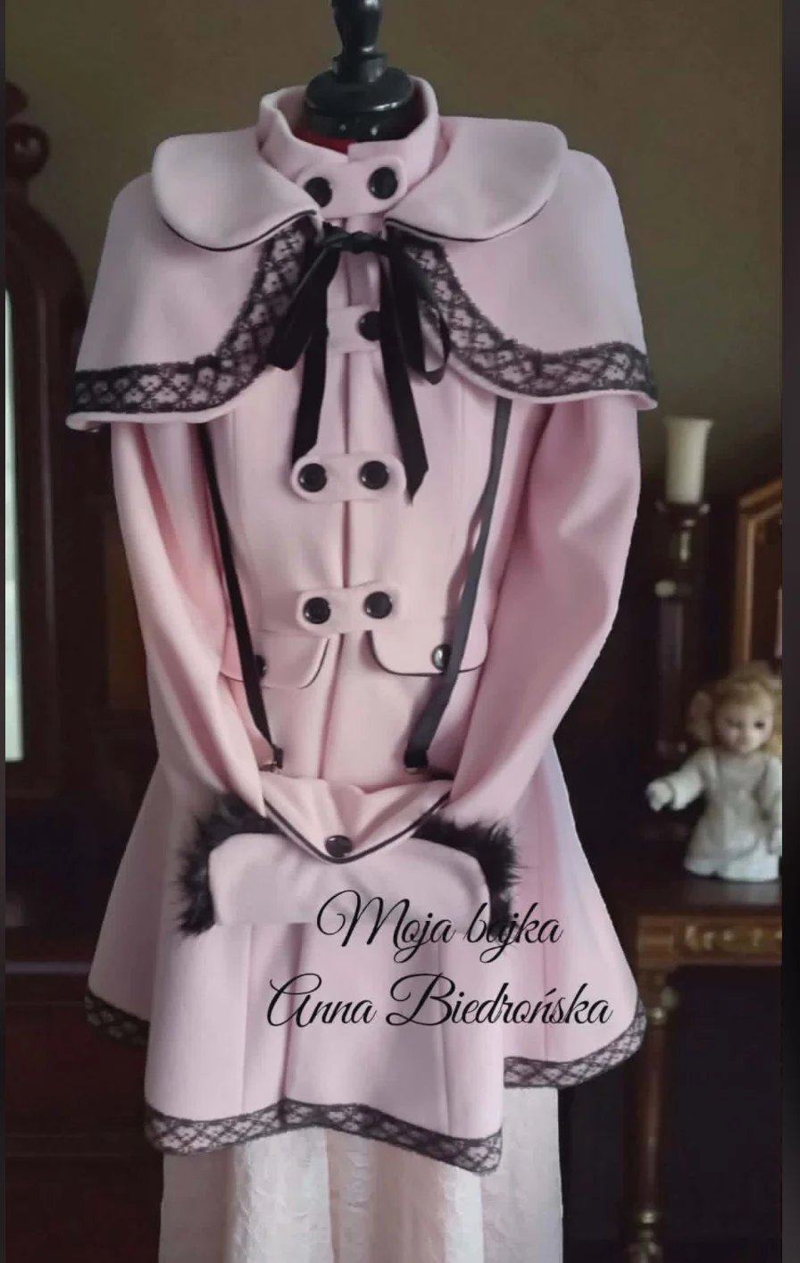 Pink vintage-style dress on mannequin with black lace collar and buttons, displayed with text reading Moja Babka Anna Biedrońska