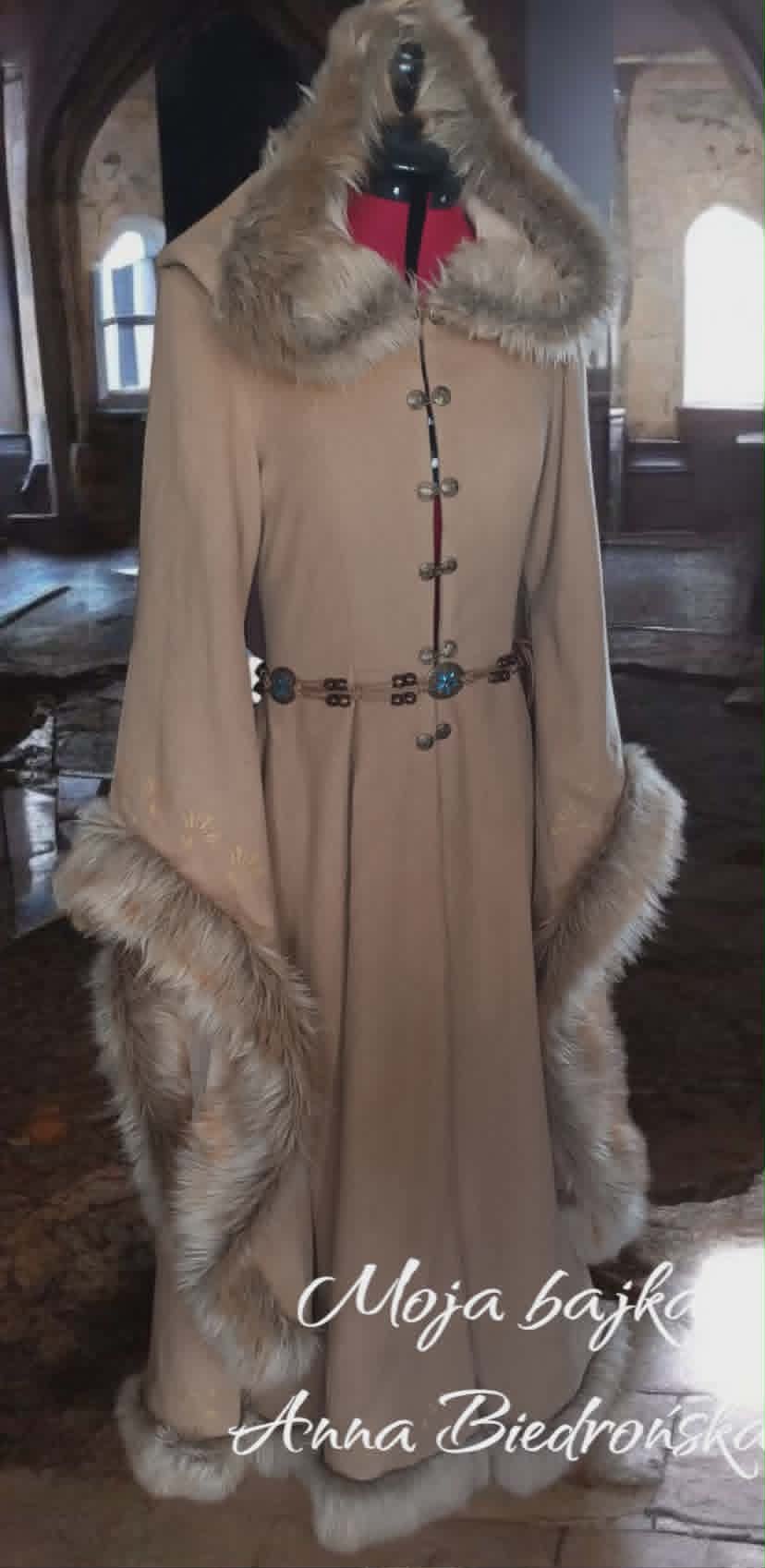 Beige wool coat with fur collar and cuffs, decorative ornamental clasp, displayed on mannequin indoors