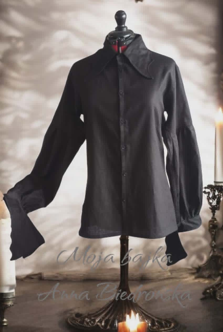 Black button-up blouse on dress form with wide bell sleeves and red collar detail, displayed against blurred background