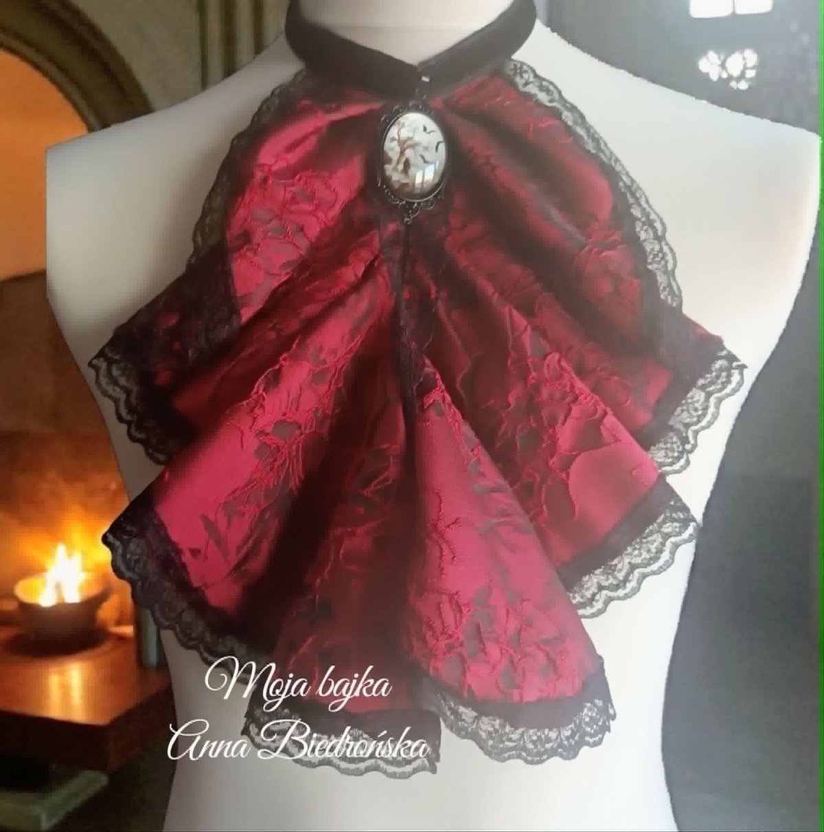 Red and black lace gothic bow brooch displayed on a dress form mannequin with clock pendant