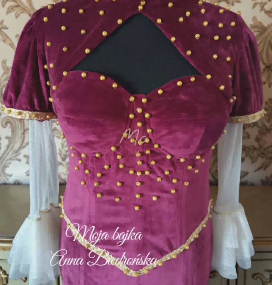 Magenta velvet dress with gold beading, white sleeves, and black shawl displayed on a dress form