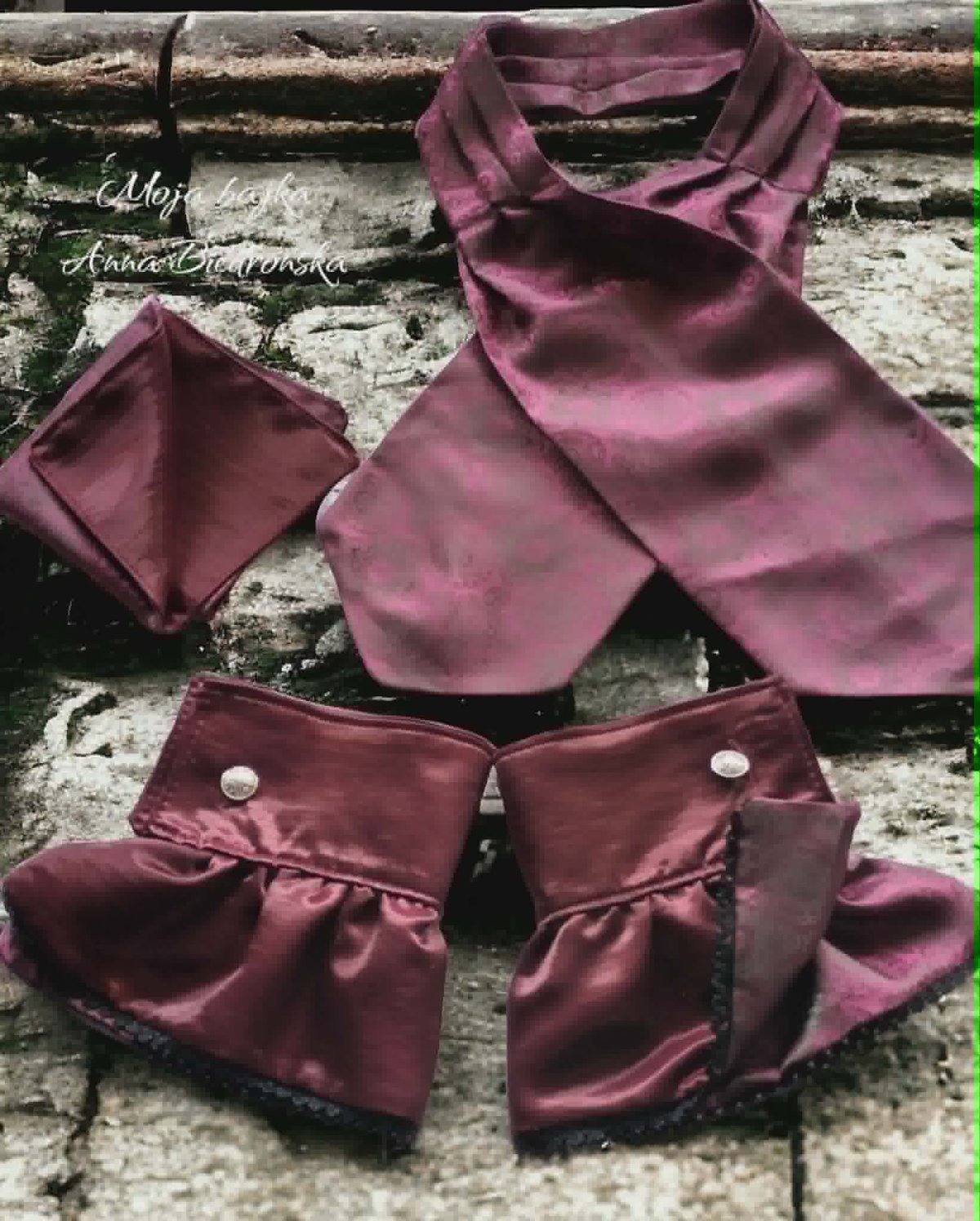 Mauve silk fabric pieces and pouches with pearl buttons arranged on weathered stone surface