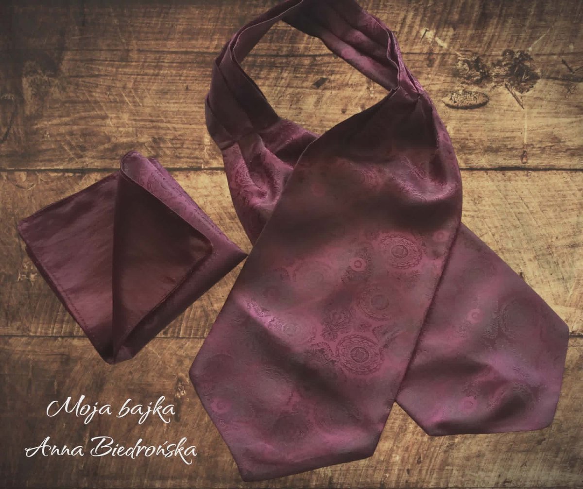 Purple silk hobo bag and matching pouch on wooden surface with designer names