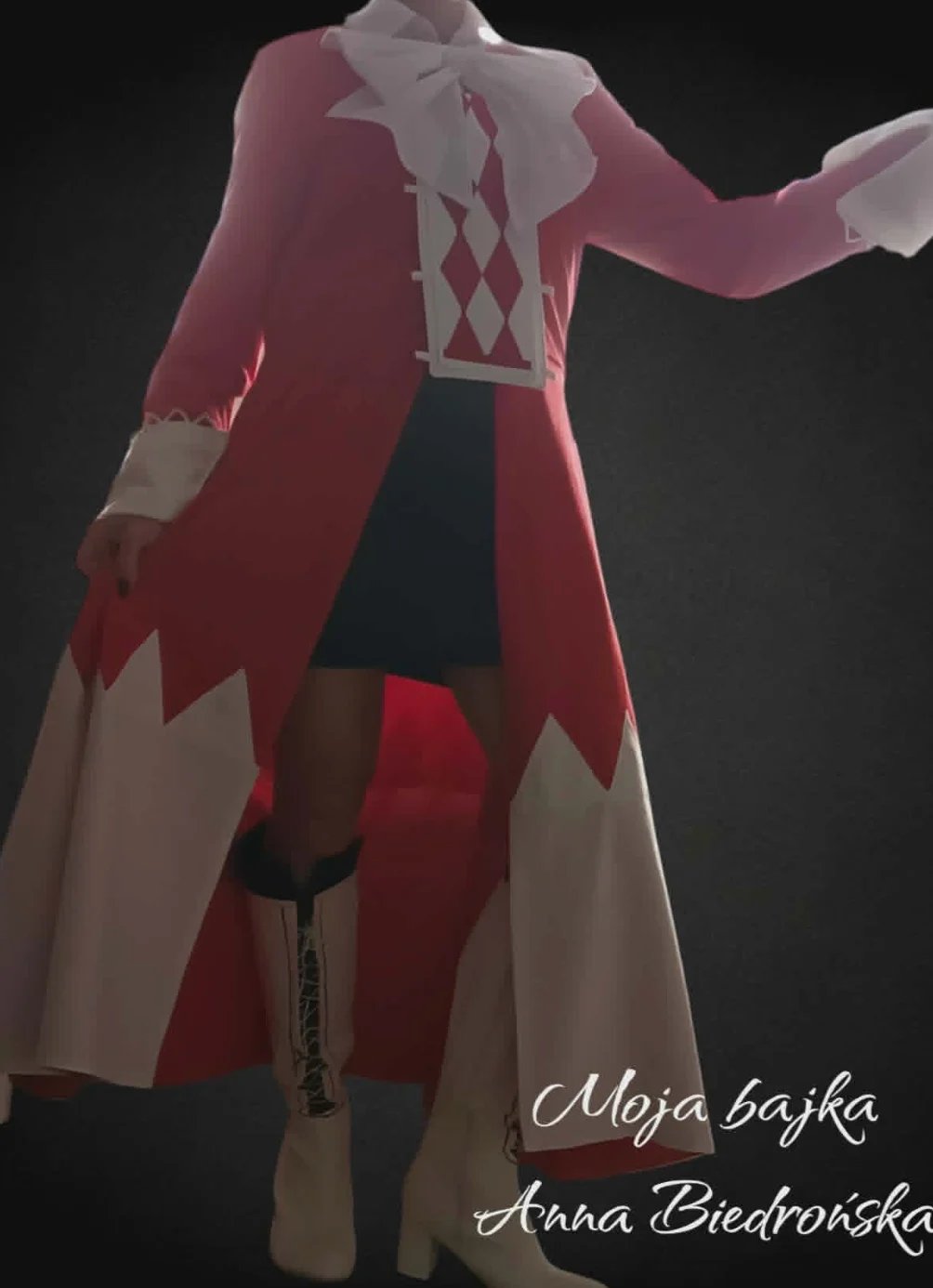 Red and cream vintage dress displayed on a dress form with puffed sleeves, diamond pattern, and asymmetrical hemline against dark background