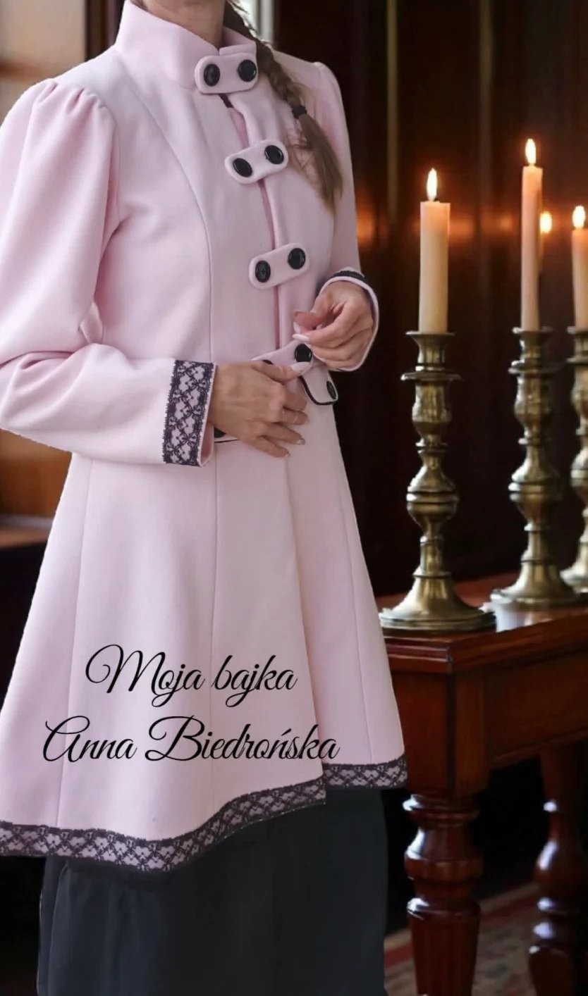 Woman in pink formal coat with lace trim standing by candlelit altar with text overlay in Polish