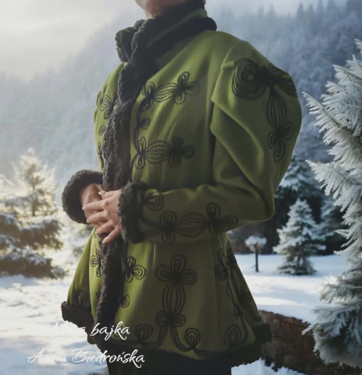 Person wearing ornate green coat holding child in snowy forest landscape