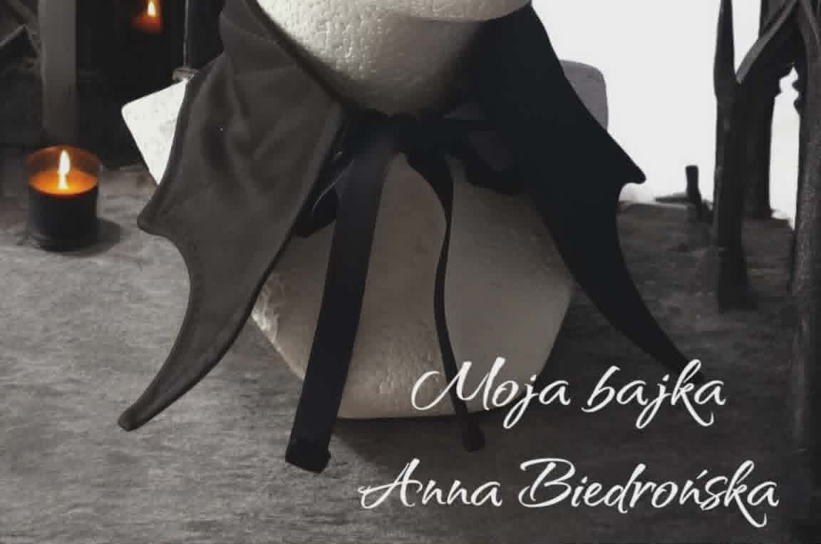 A draped black fabric adorned with a black bow, positioned against a moody cemetery backdrop with candles and gravestones, featuring overlaid text names