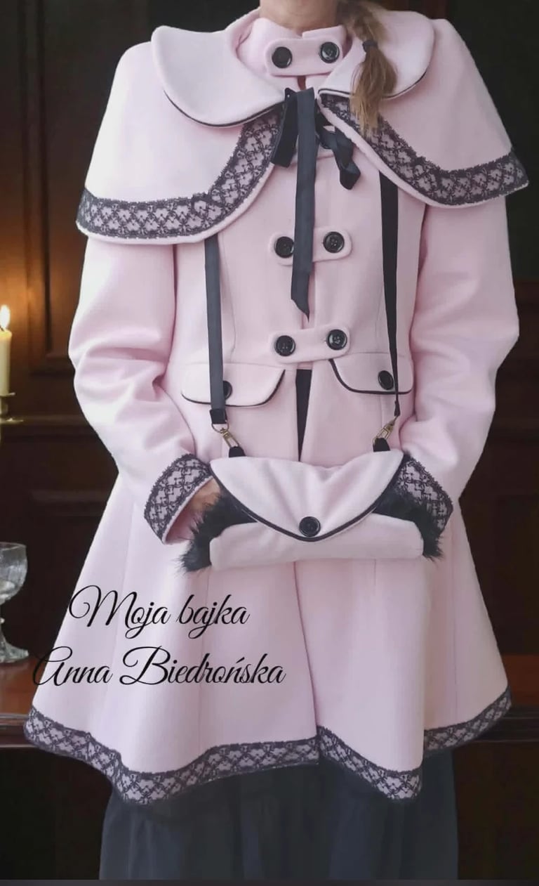 Person wearing pink double-breasted coat with large white collar, black ribbon bow, and lace trim, displayed on a dress form