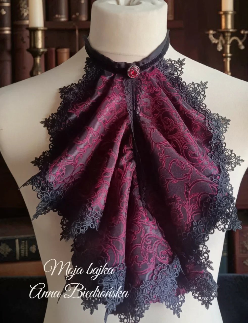 Purple and black ornate lace jabot collar displayed on a dress form mannequin with decorative candles in background