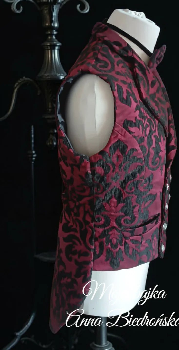 Burgundy damask patterned vest with black embroidered designs displayed on dress form with white cowboy hat