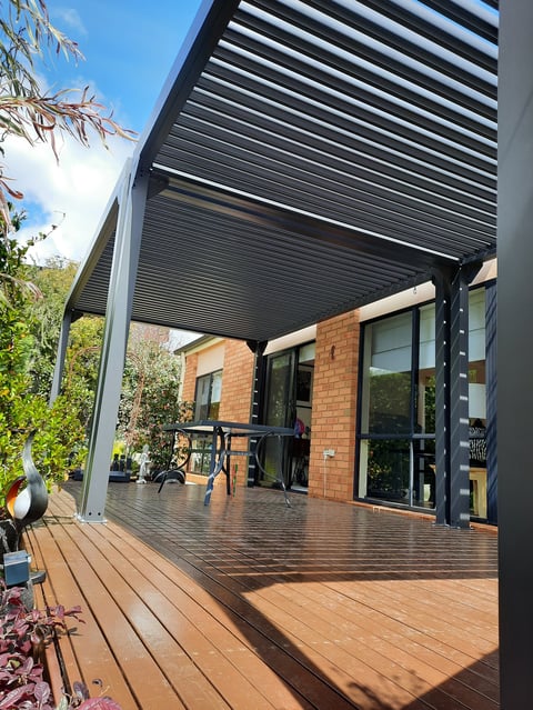 Pergola installation - modern motorized louver roof over timber deck attached to brick home, Geelong handyman project