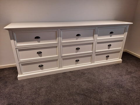 Flat pack furniture assembly - white wooden nine-drawer dresser assembled on carpeted floor in Geelong home