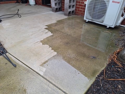 Pressure washing in progress - concrete patio partially cleaned showing dramatic dirt vs clean contrast, Geelong handyman at work