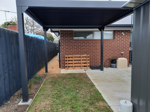Black pergola over brick patio - Geelong handyman pergola installation with concrete flooring and lawn