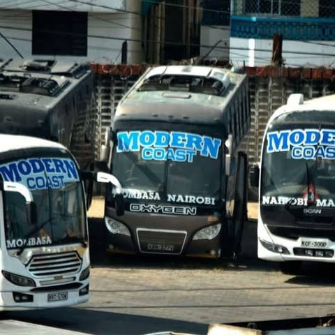 Row of Modern Coast buses parked in a depot, white and grey colored vehicles with blue branding and Nairobi destination text