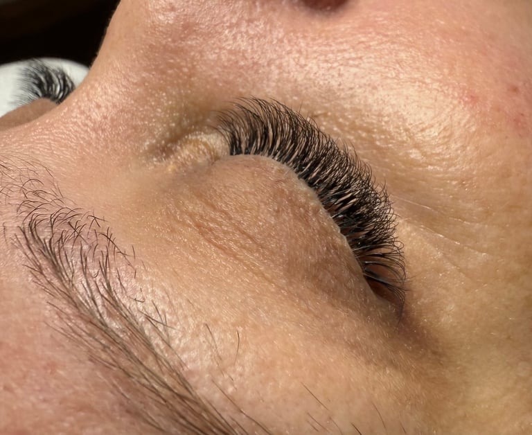 Close-up of eyebrows showing natural hair and sculpted brow shape on skin