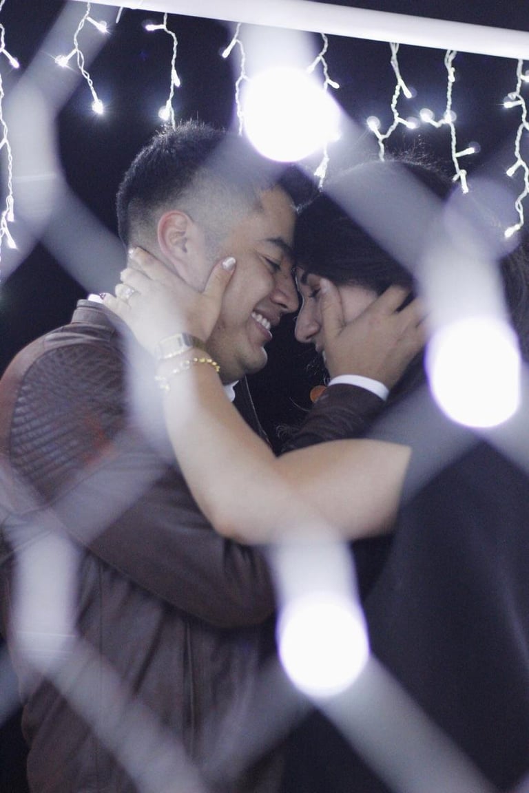 Two men smiling and embracing with lightning effects and blurred lights in the background