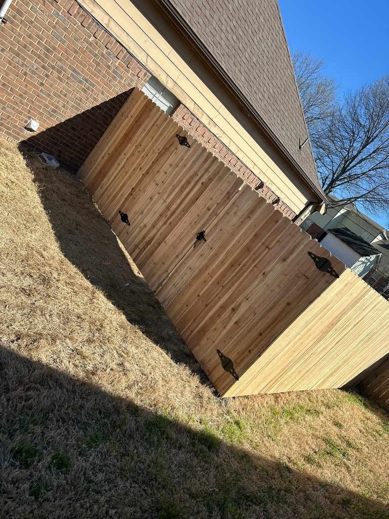 Wooden garage door on brick house with clear blue sky and bare tree in background