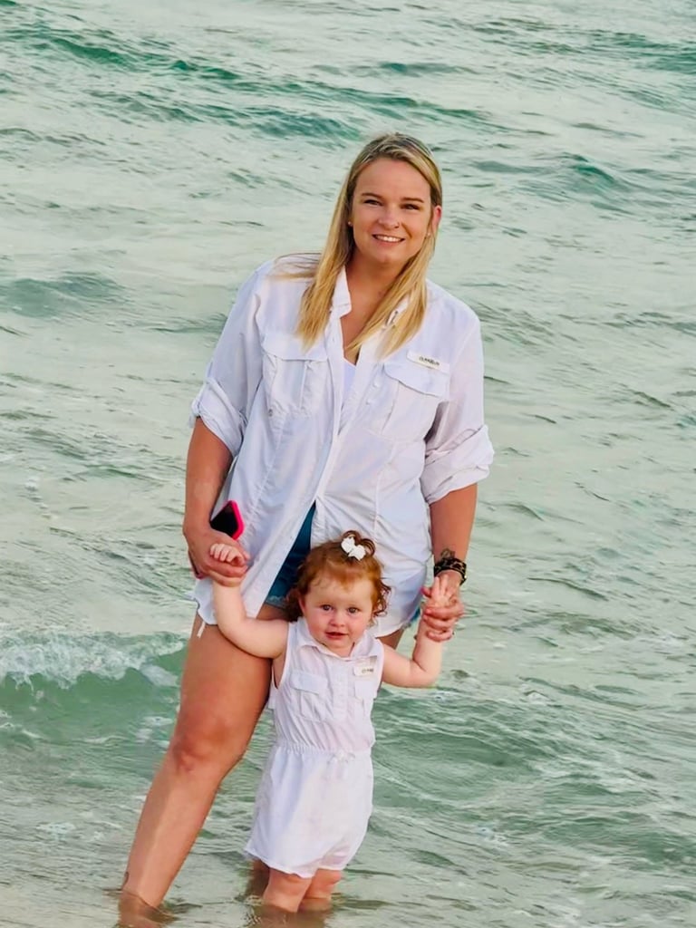 Kyla, Administrative Office Manager at North Slope Exteriors, on a beach with her daughter