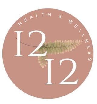 Circular badge with Health and Wellness 12:12 text in white with a delicate green fern leaf on mauve background