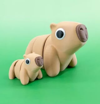 Two beige ceramic pig figurines with large blue eyes and gray ears on a green background, one large and one small