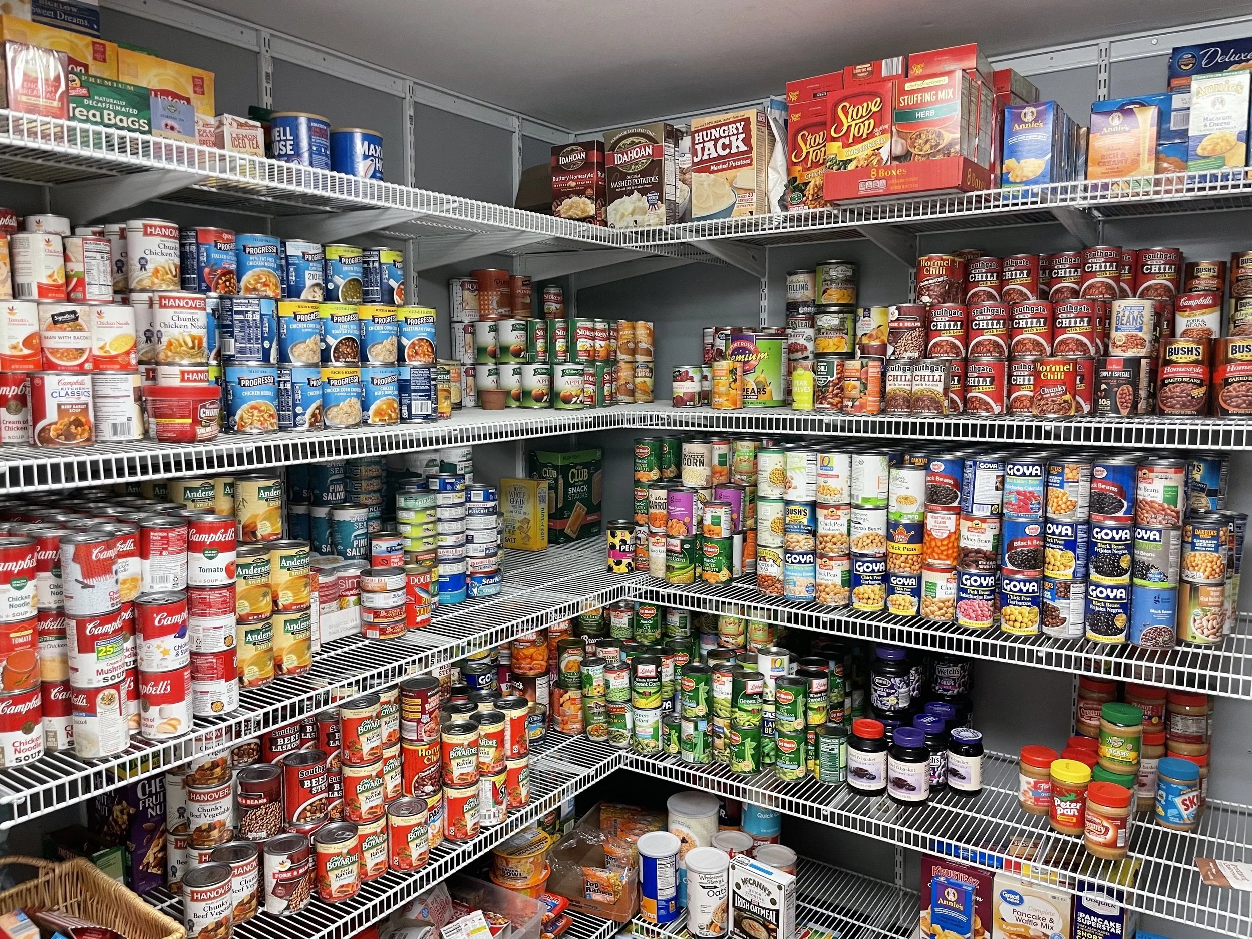 Stocked pantry shelves filled with canned goods, jars, and packaged food items organized by type