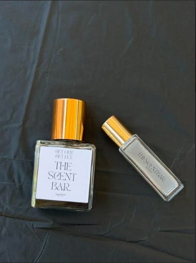 Two perfume bottles with gold caps on dark textured background — The Scent Bar collection