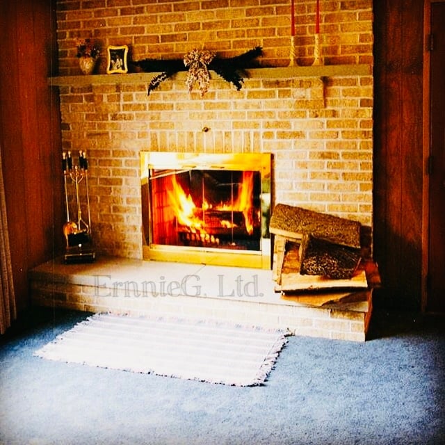 Fireplace with warm glowing fire and brick surround