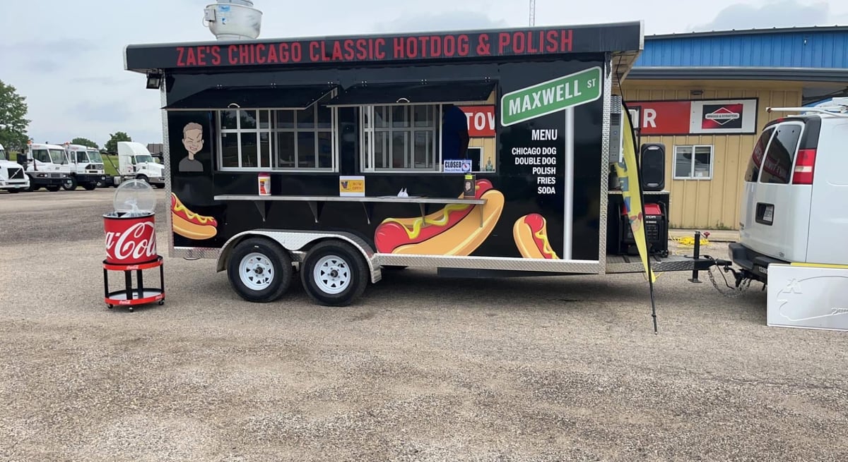 Black food truck with giant hot dog graphic