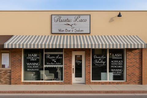 Rustic Lace Wax Bar and Salon storefront with striped awning and brick facade