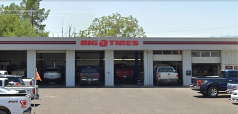 Big O Tires storefront with service bays and parked vehicles in front lot