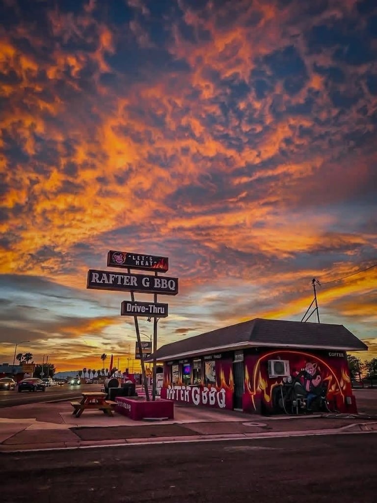 Rafter G BBQ drive-thru restaurant with vintage signage at sunset under dramatic orange and purple sky