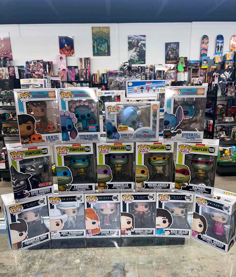 Collection of Funko Pop figures and collectibles displayed on shelves in front of posters and merchandise wall