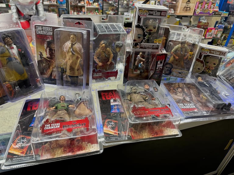 Collection of action figures and collectible toys displayed on a table at what appears to be a store or convention
