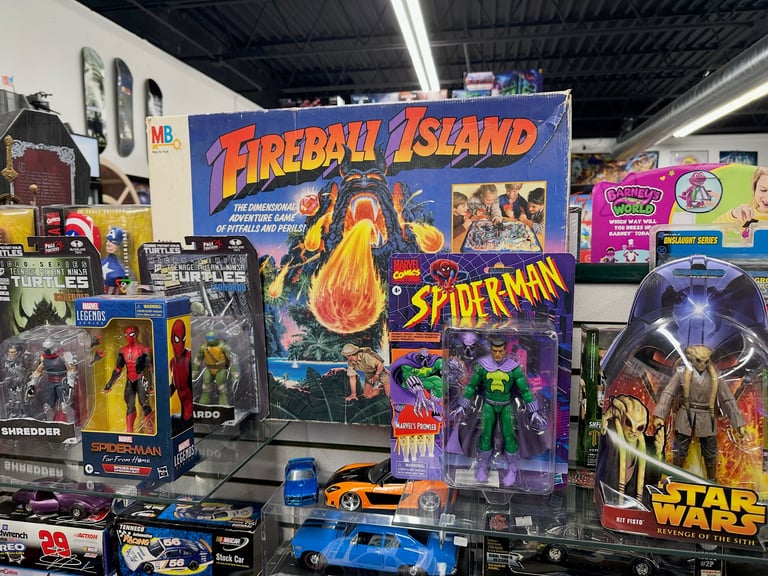 Vintage arcade game cabinet Fireball Island displayed among collectible action figures and toy vehicles at a store or convention