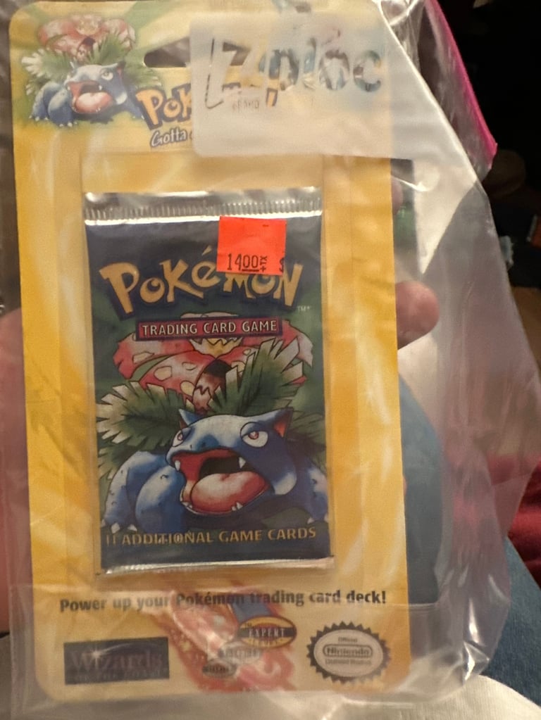 Sealed Pokemon Trading Card Game booster pack in yellow packaging with artwork of a red and blue Pokemon character
