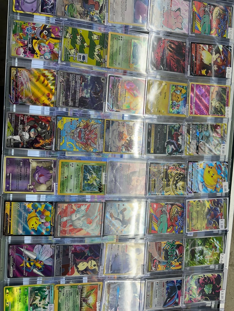 Collection of trading cards displayed in a clear plastic binder with multiple rows of colorful Pokemon and other character cards