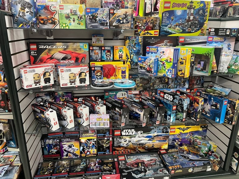 Retail display shelf filled with collectible toy sets and building blocks in colorful packaging, including LEGO and action figures.