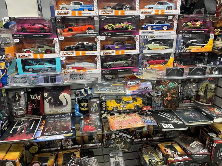 Colorful collection of die-cast model cars displayed on shelves and surfaces, organized by color and manufacturer.
