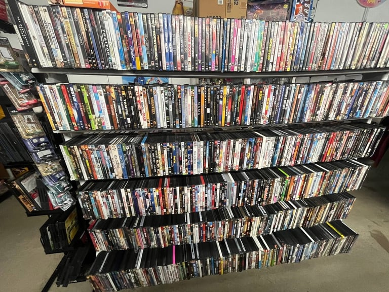 Large black shelving unit displaying hundreds of organized DVD and Blu-ray cases arranged in neat rows