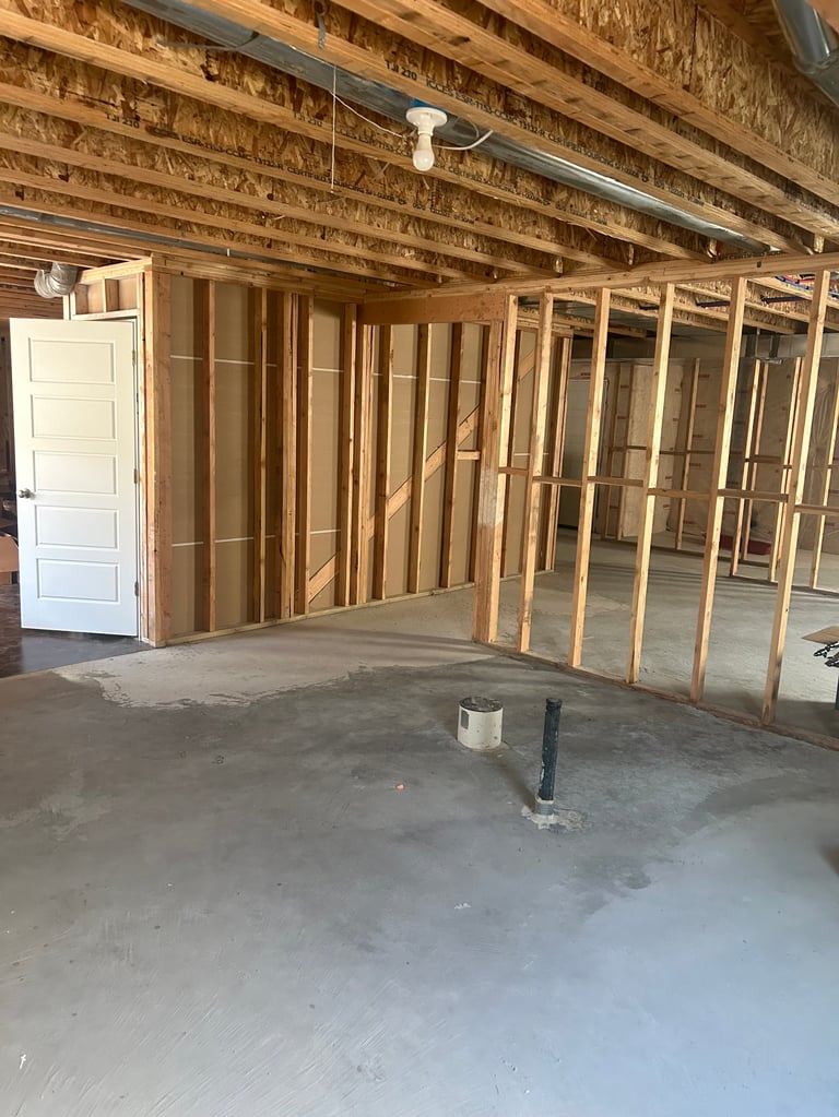 Basement interior with new wood framing and concrete floor mid-build