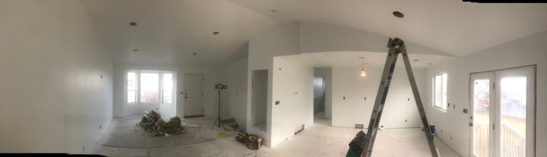 Interior of an under-construction home with white drywall and fresh doorways