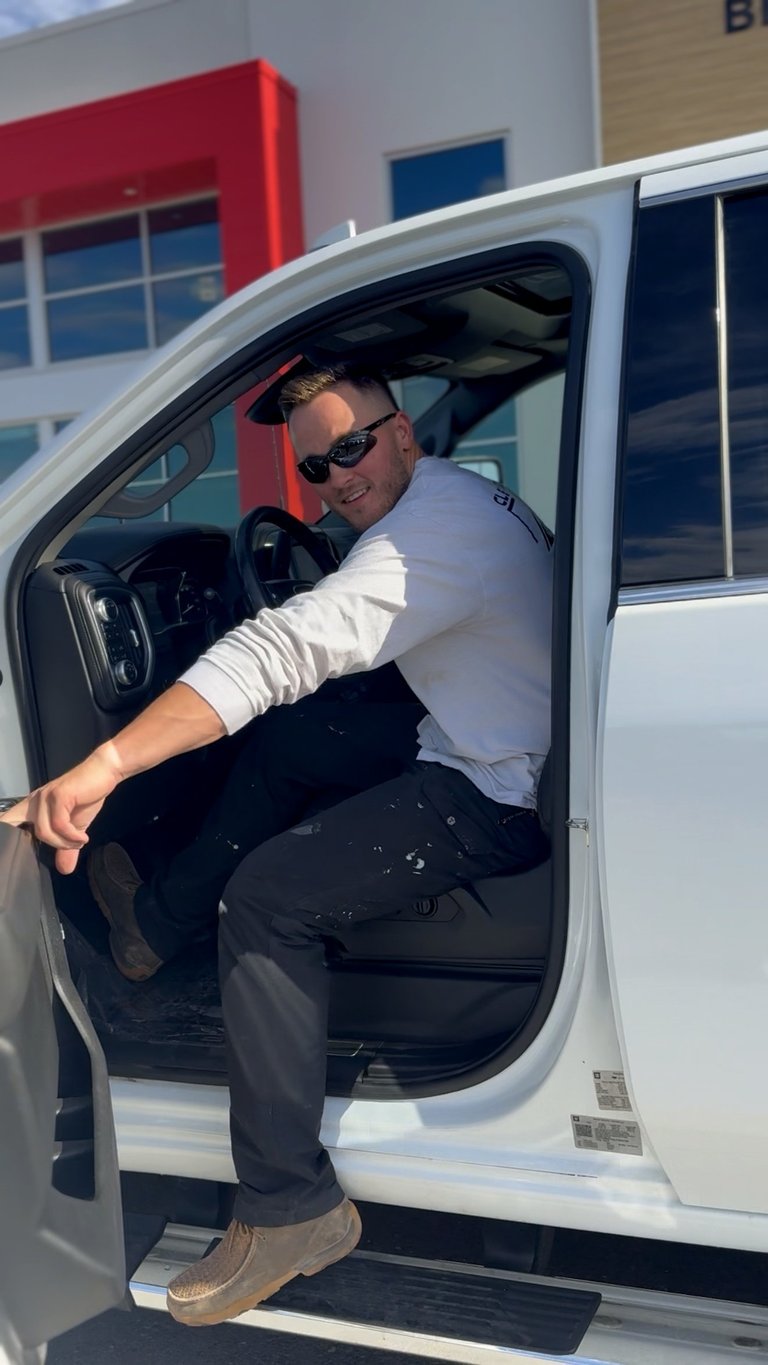 Riley, the owner of Clean Edge Construction, stepping out of his work vehicle at a job site
