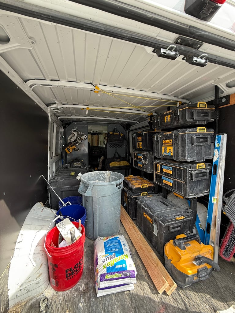 Inside the Clean Edge work van showing stacked DeWalt storage cases, tools, and materials organized on shelving