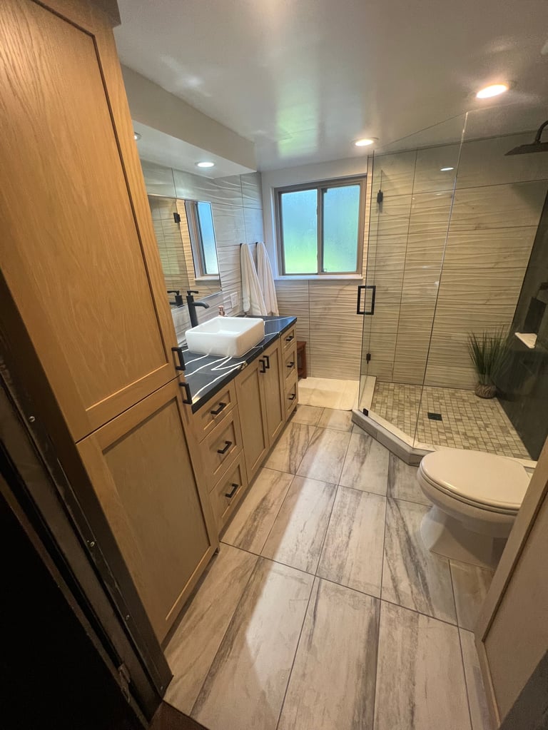 Bathroom with wood-toned vanity, white countertop and sink, and warm wood-look flooring