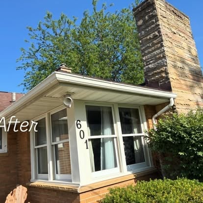 After: Modern white addition to brick home with double doors and windows, freshly cleaned